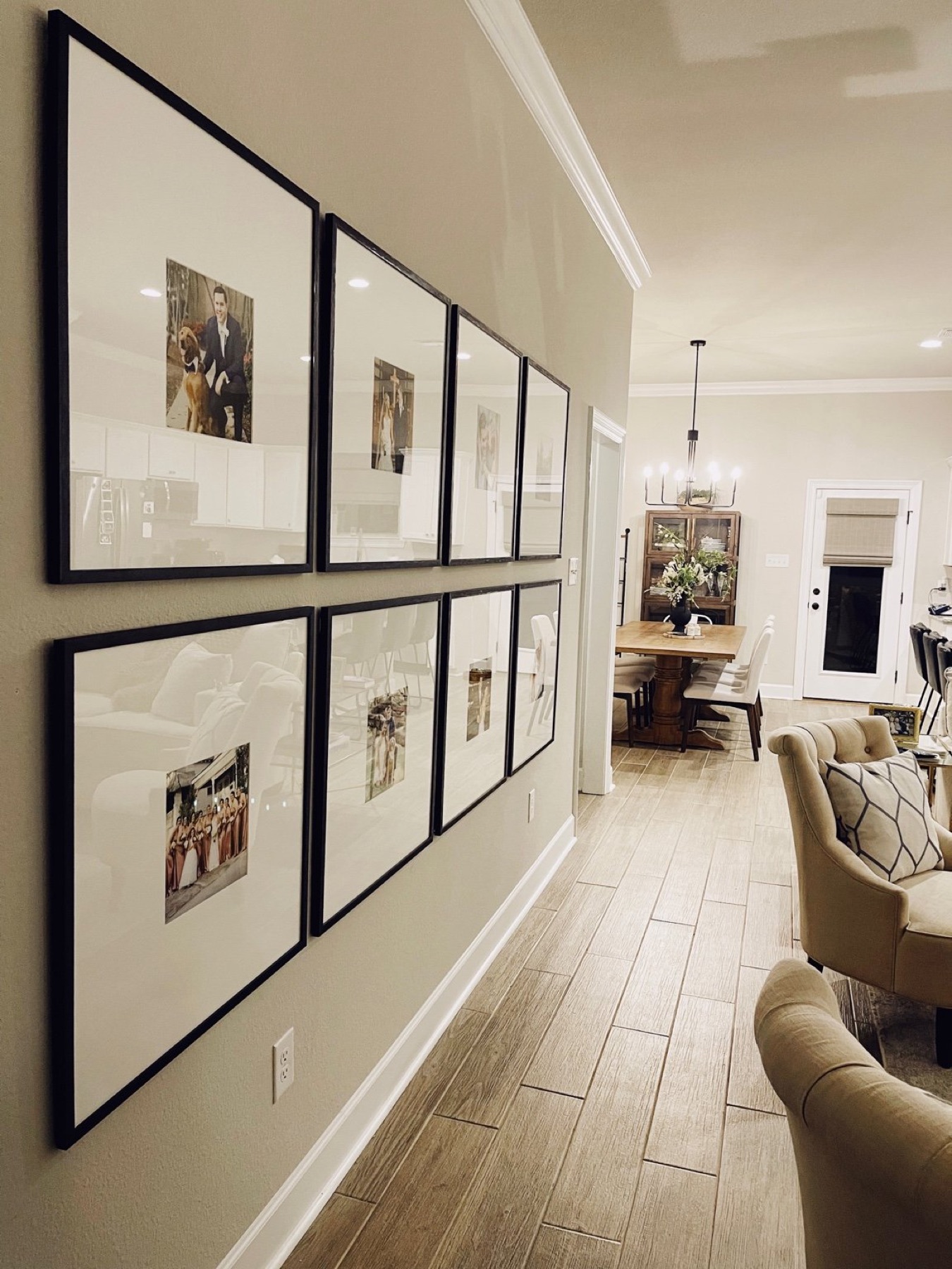 Gallery wall of matching black custom-framed family portraits installed in a North Louisiana home